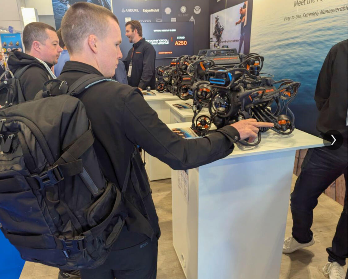 Attendee interacting with underwater ROV display at Oceanbotics trade show booth designed by Sea Ranch Studio