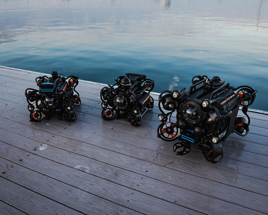 Three SRV-8 ROV units staged on a dock at sunset for Oceanbotics trade show marketing photography