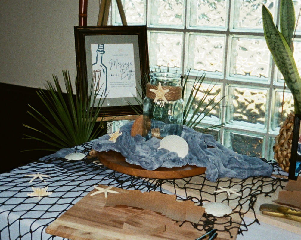 Message in a bottle memorial guestbook display with seashells and fishing net for nautical celebration of life, Orange County