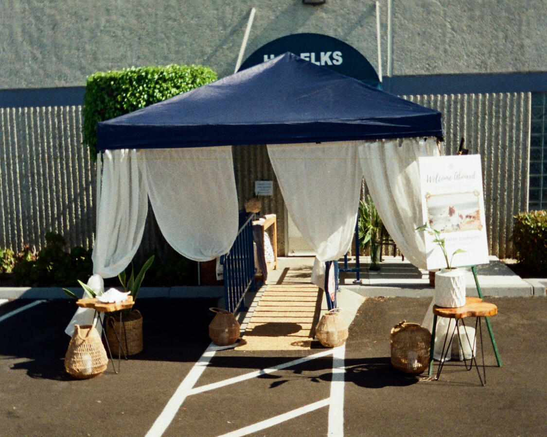 Draped white tent entrance with coastal decor for nautical-themed celebration of life, Orange County