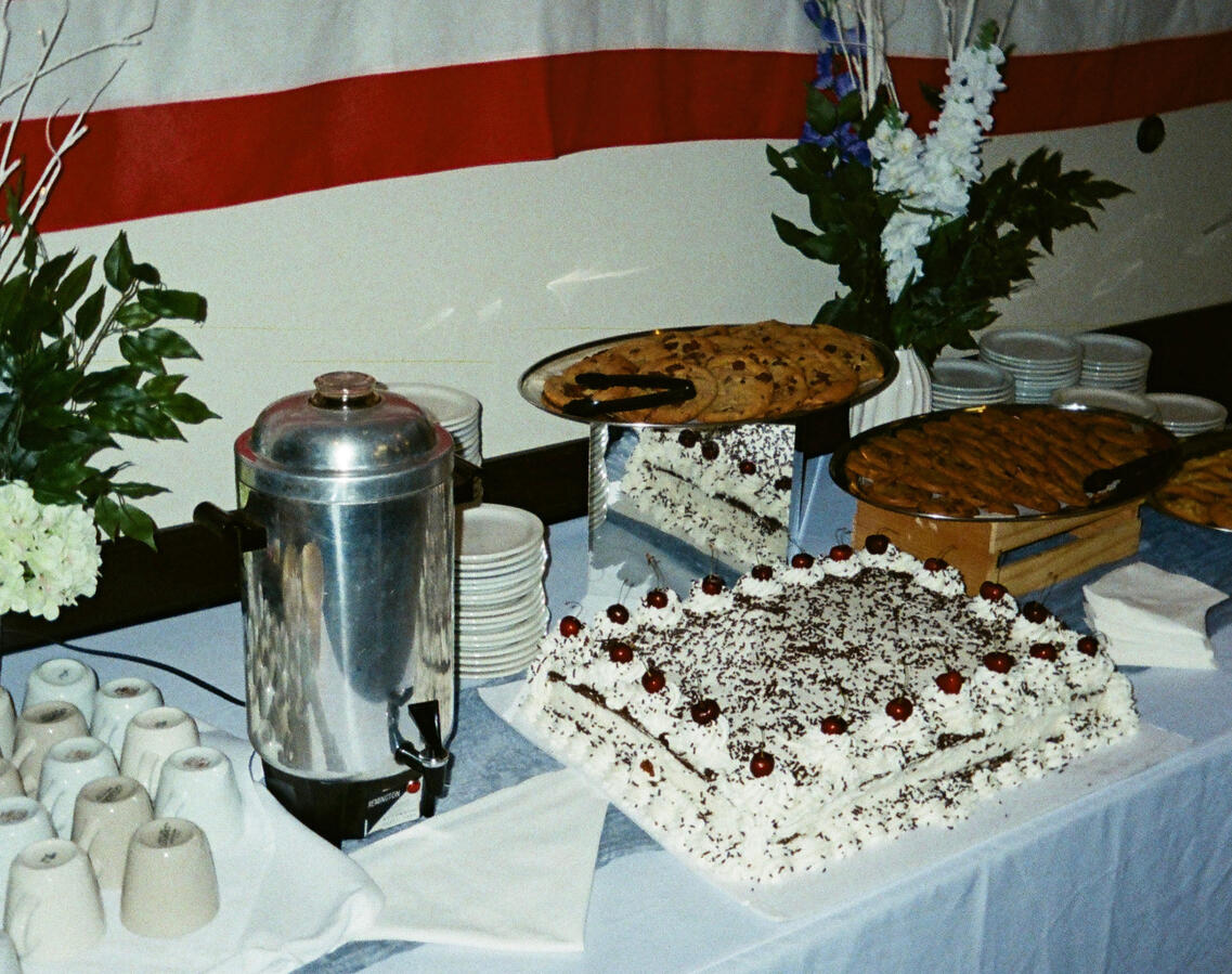 Dessert table with cake and floral arrangements for celebration of life event, Orange County event planning