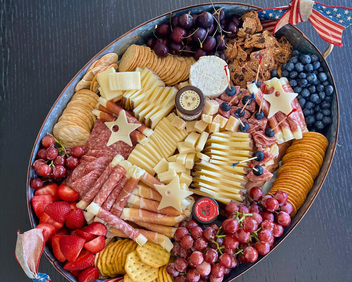 Red white and blue charcuterie board with star-shaped cheese and berries for Fourth of July baby shower, Orange County